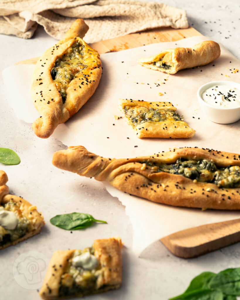 Vegane Pide mit Spinat und Joghurt auf einem Brett