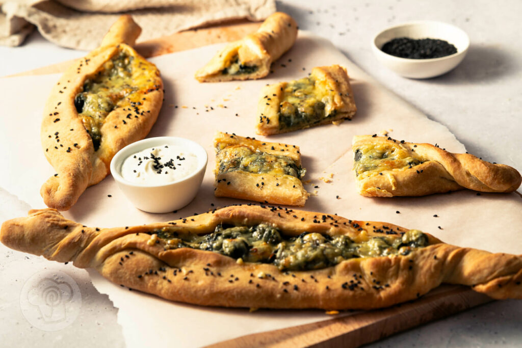 Vegane Pide mit Spinat und Joghurt auf einem Brett
